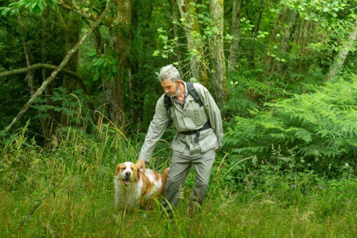 middle-aged man with dog walking in nature